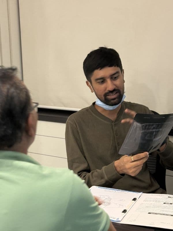 Dr. Pratik Pipalia reviewing dental X-rays and scans with a patient